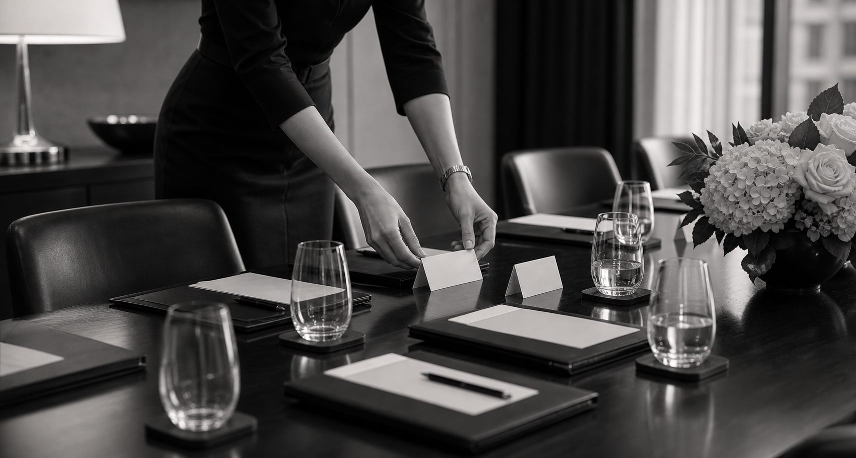 Personal assistant preparing place cards and folders for a private meeting
